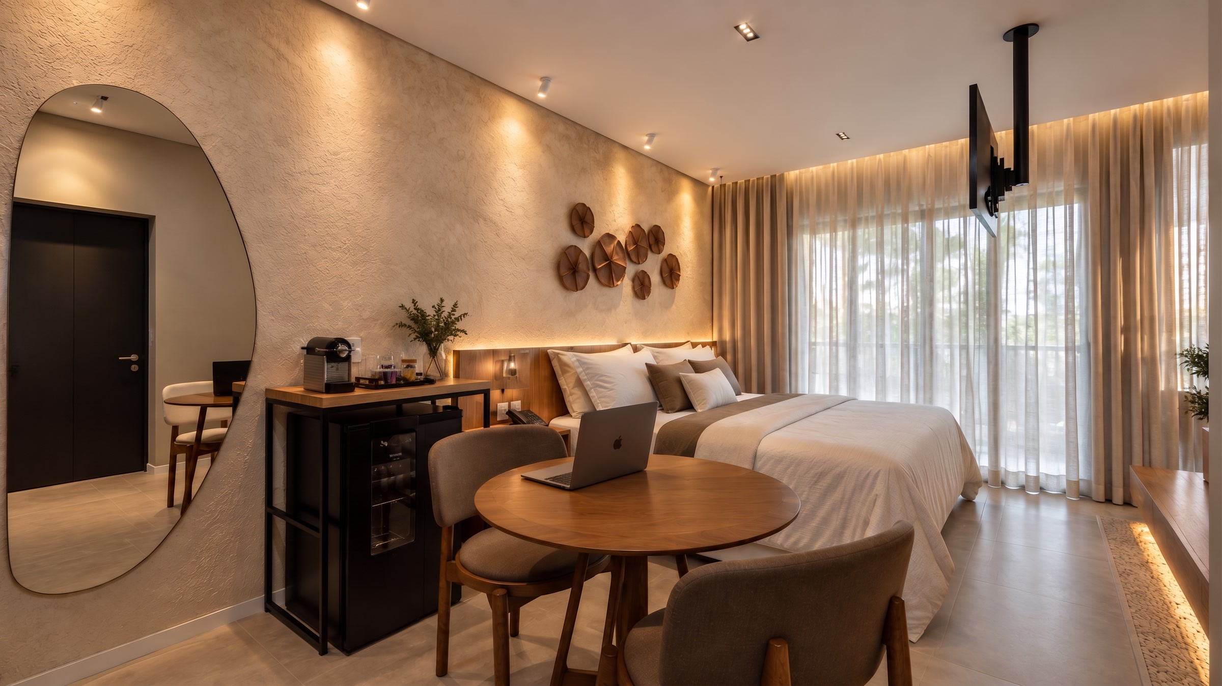 Quarto unitário com cama de casal, mesa de trabalho redonda e TV
